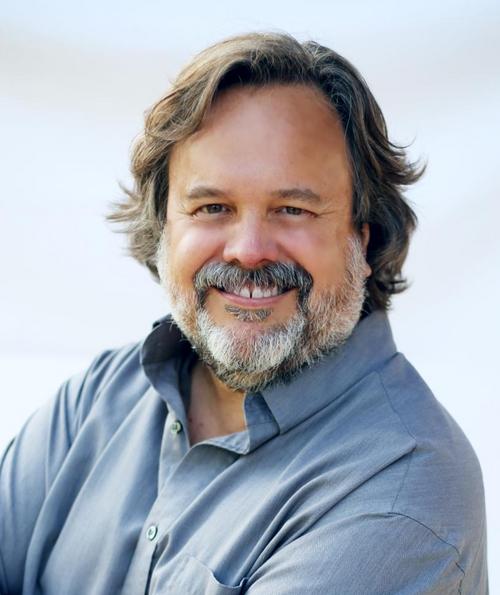 Scott Davis is a white man whose messy dark hair might make him look younger than he is, but the amount of gray in his beard lets you know exactly how old he is.